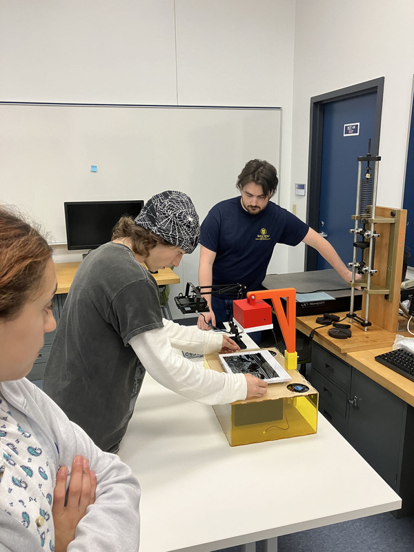 Student working on project as others look on