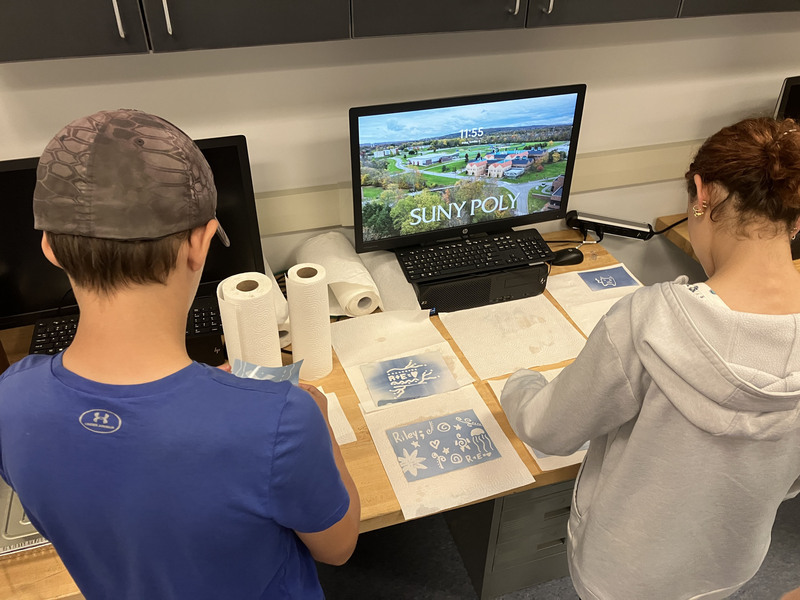 Students working on project with stencils near computers