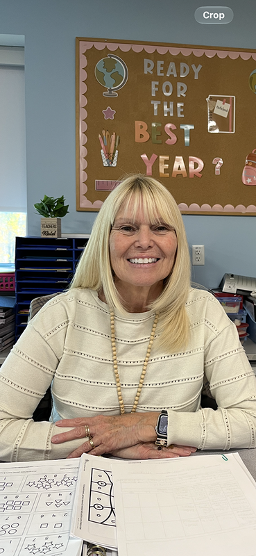 Darlene Brewer sitting at a desk with a sign behind her that says "Ready for the best year?"