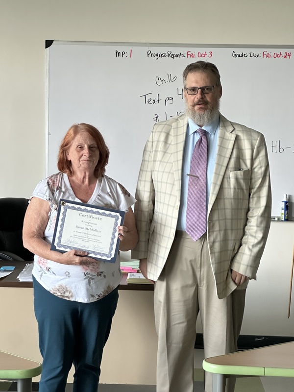 Susan McMullen and Zane Mahar with Susan McMullen holding her 10 years of service certificate