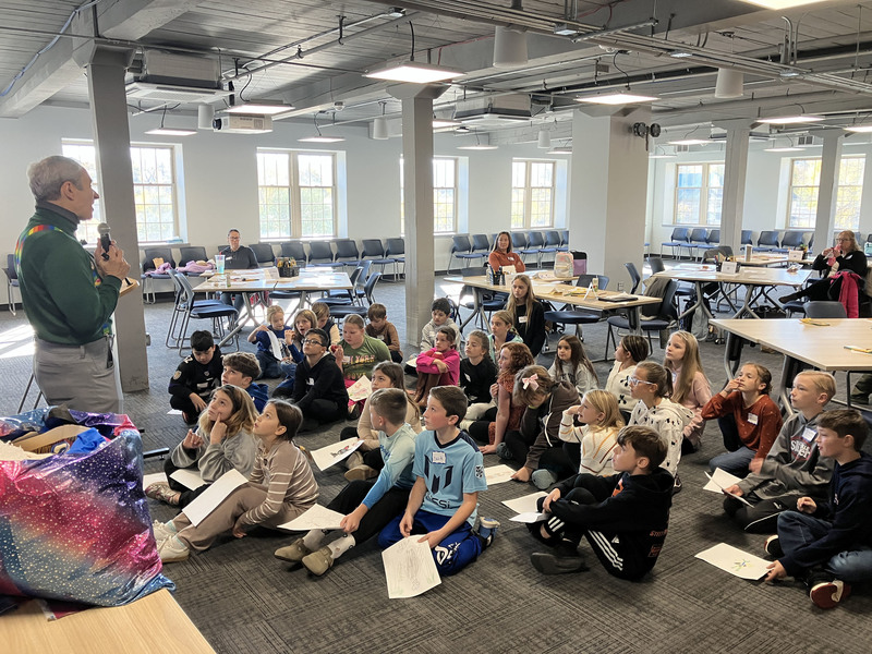 Author speaking to students who are sitting on the floor
