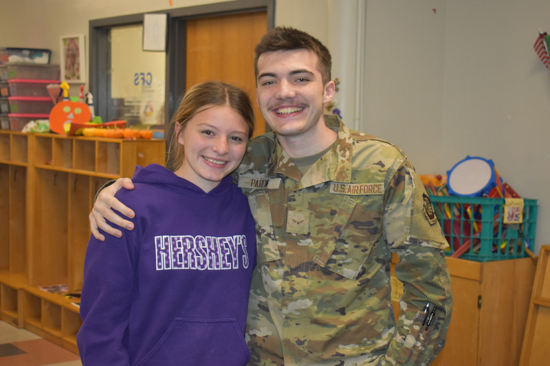 Brother and sister with arms around each other posing for photo