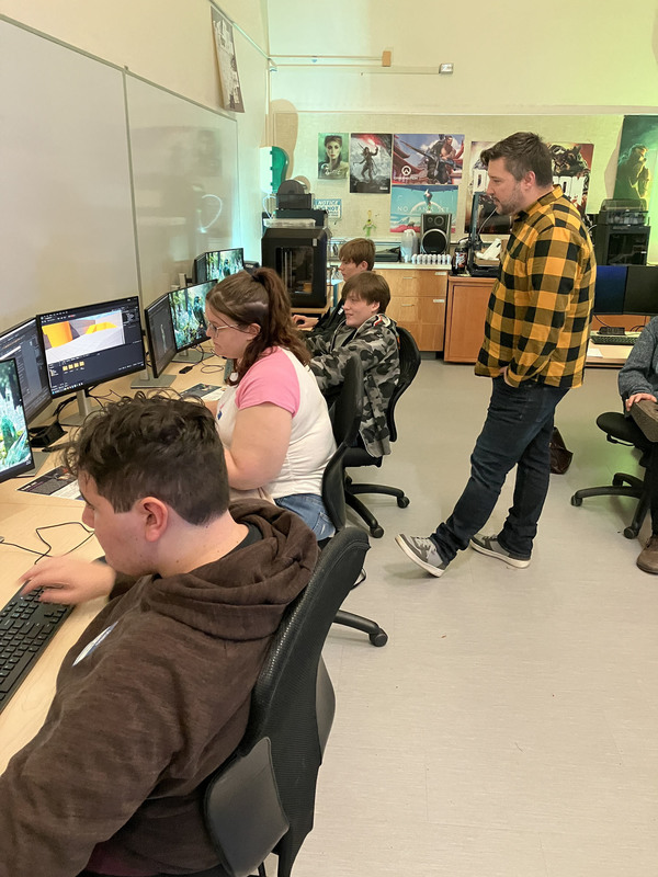 Assistant professor overlooking a few students working in computer lab at MVCC