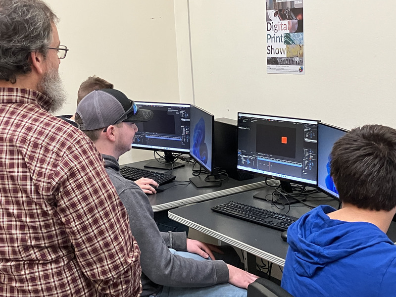 Assistant professor overlooking a couple of students working in computer lab at MVCC