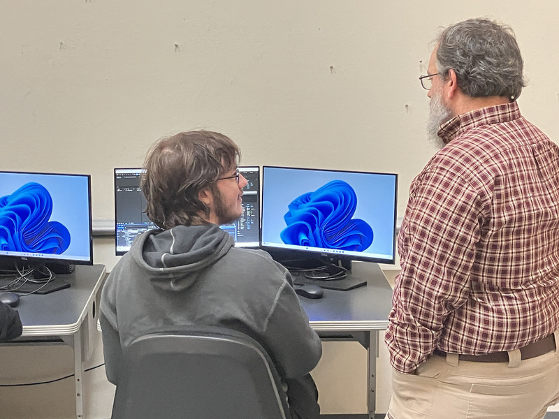 Student in computer lab with assistant professor