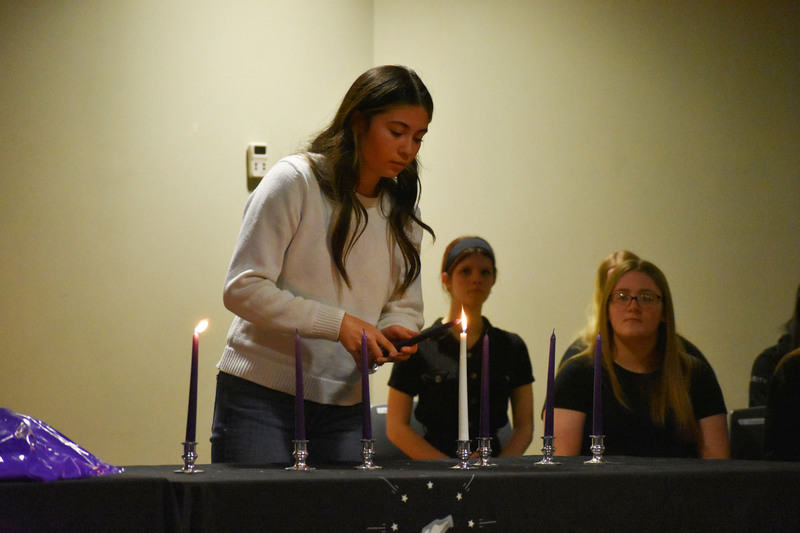 NTHS member lights a candle during candle-lighting ceremony