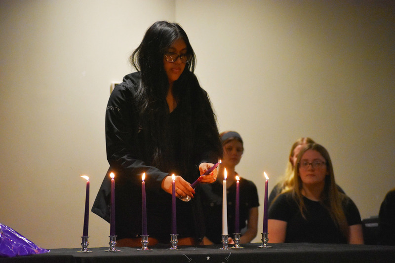 NTHS member lights a candle during candle-lighting ceremony