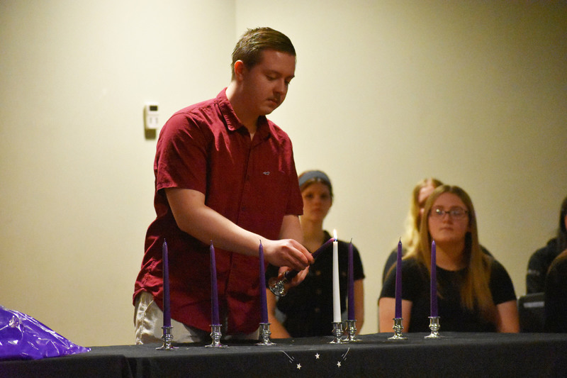 NTHS member lights a candle during candle-lighting ceremony