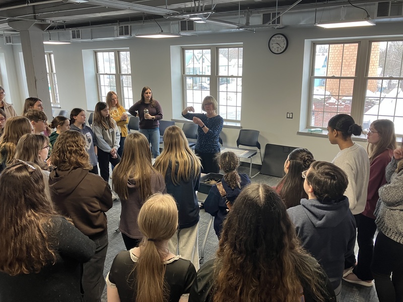 Students look on as Nancie Cooney discusses basket-making