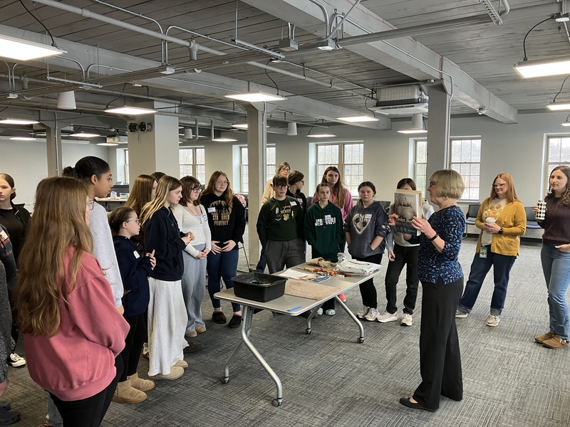 Students look on as Nancie Cooney discusses basket-making