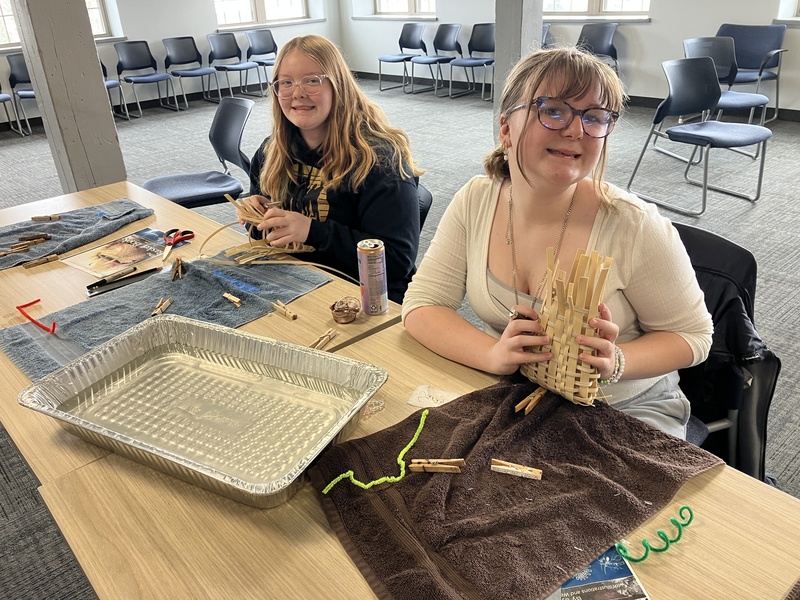 Students posing while working on baskets