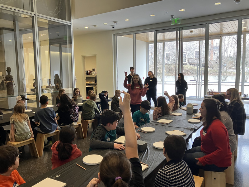 Students at tables at art museum