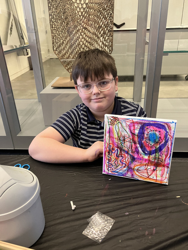 Student displaying artwork at art musem