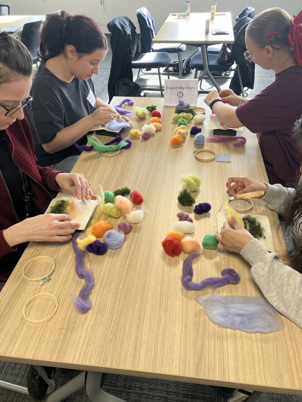 Students working on needle felting at a table