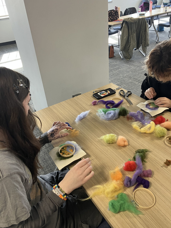 Students working on needle felting at a table