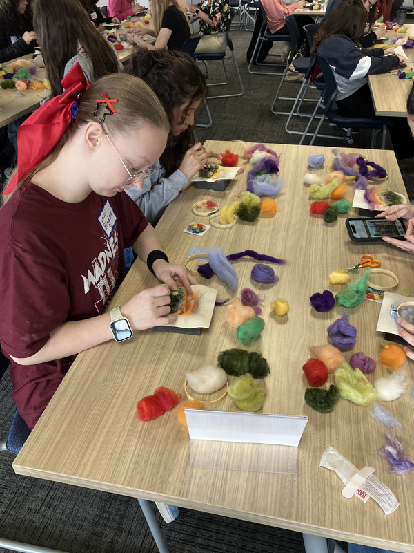 Students working on needle felting at a table