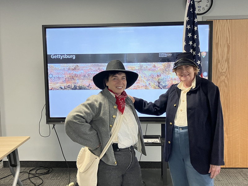 Two performers wearing clothing for Civil War presentation and posing together