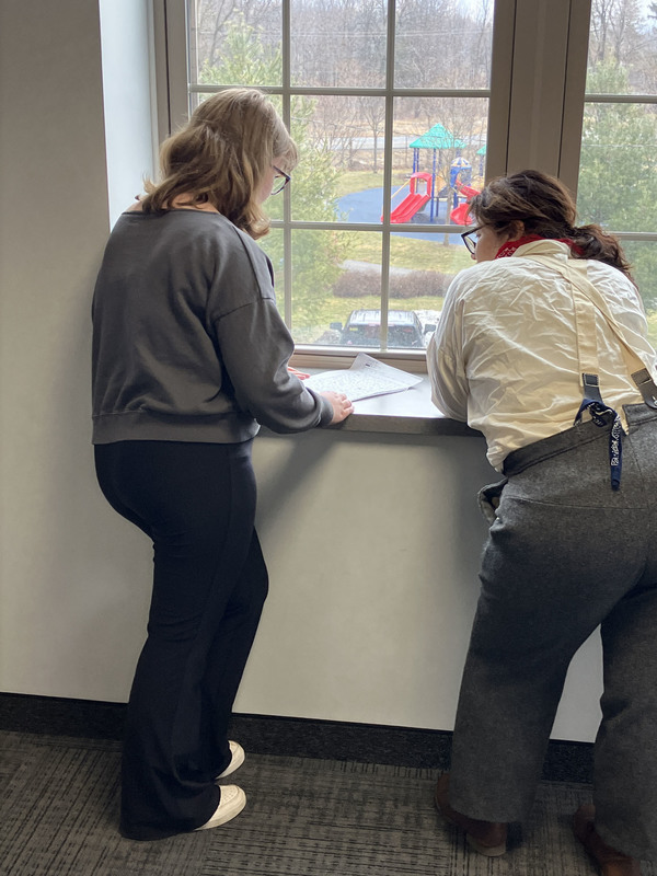 Two people by window working on presentation