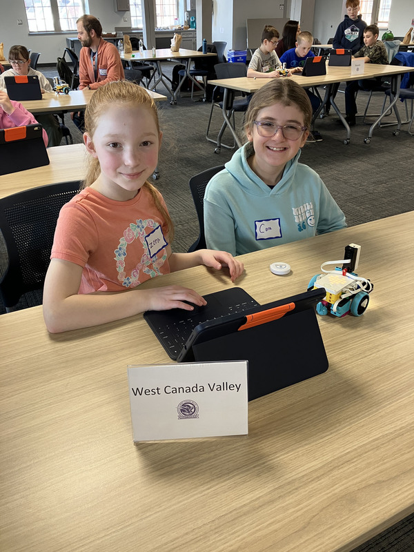Students at table with robot and robot