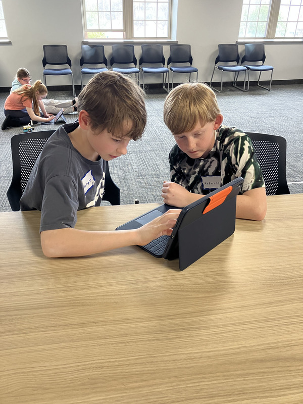 Students at a table using a tablet