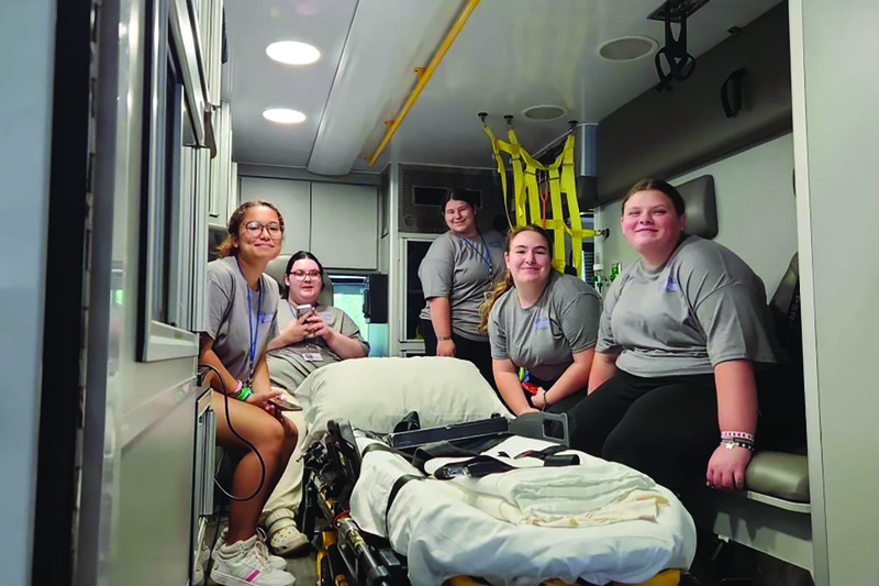 Students in the back of an ambulance posing for a photo