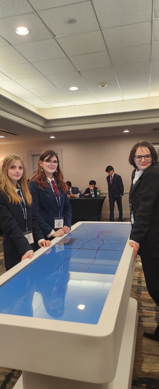 Three students pose with Anatomage Table at state HOSA Conference