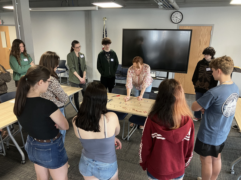 Artist standing presenting to standing high school students