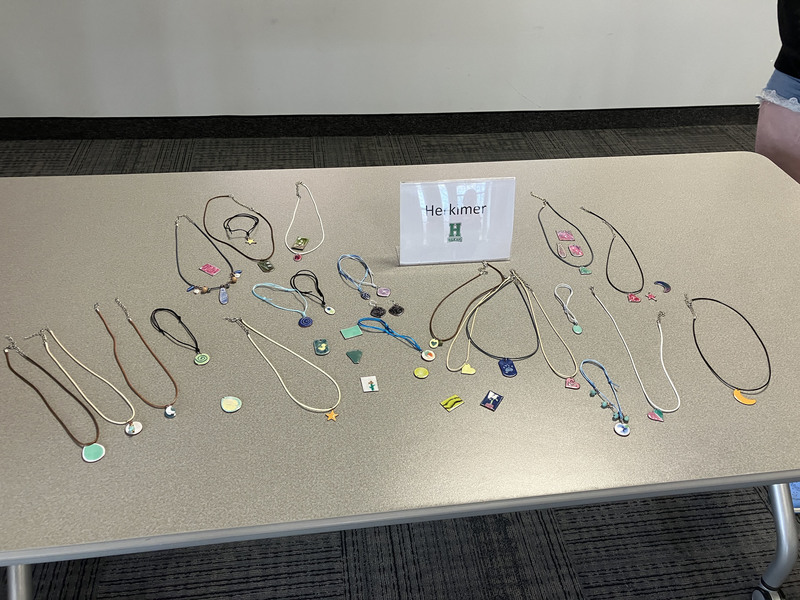A table covered with jewelry and a sign that says Herkimer