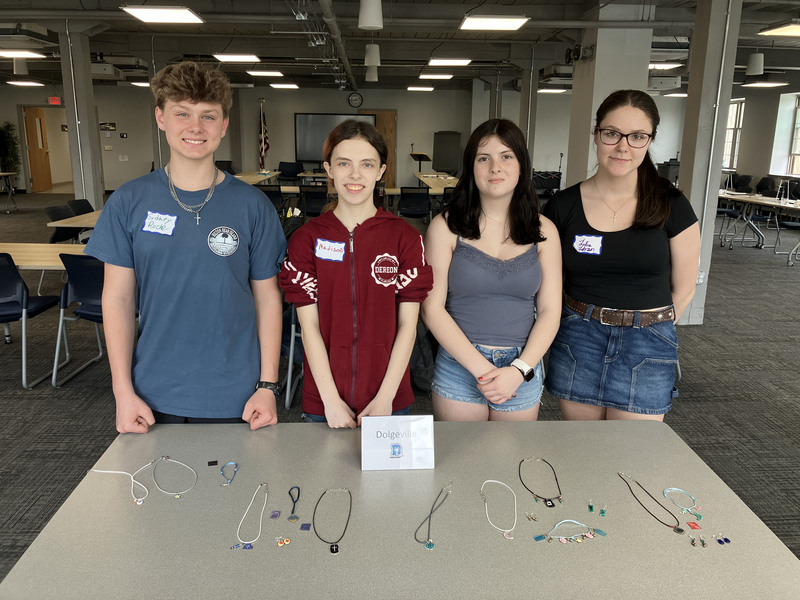 Four students posing for photo with jewelry they made