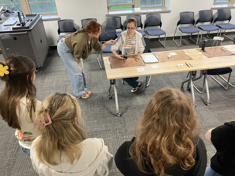 Artist and students working on art/jewelry project