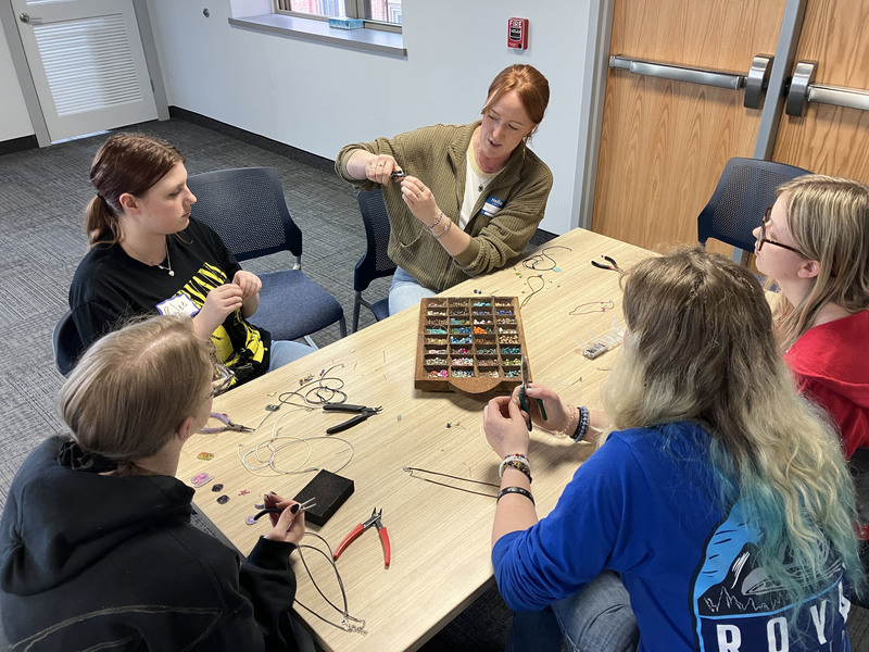 Artist and students working on art/jewelry project