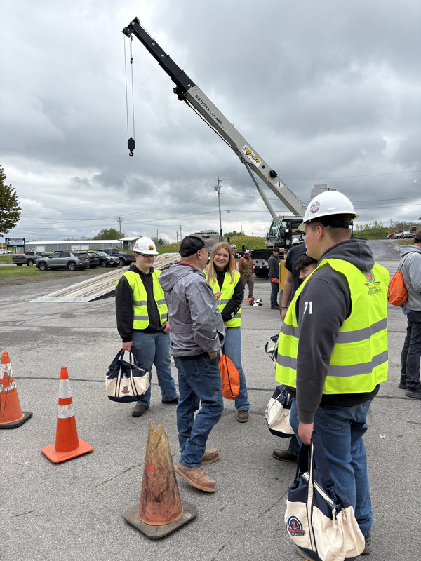 Students and others outside at Oneida County DPW with a crane in the background