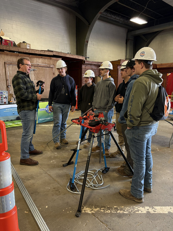 Students in hard hats listening to presenter