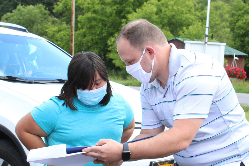 Tim Johnston presents a diploma to a student during Senior Recognition Caravan