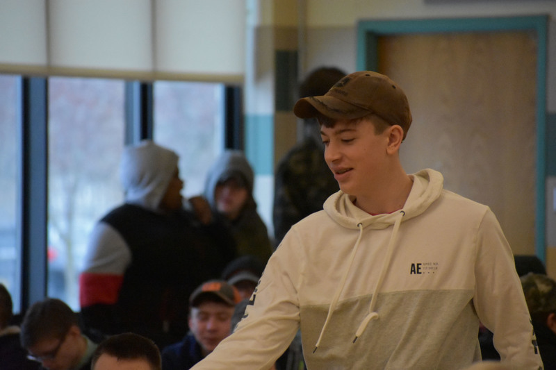 Former Pathways Academy student walks through cafeteria to accept an award