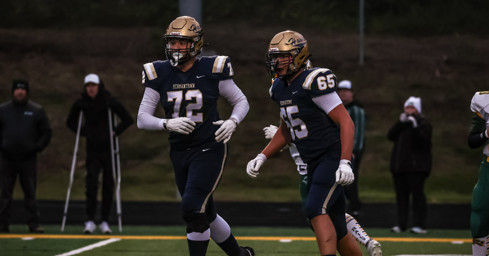 Hermantown football players run onto the field