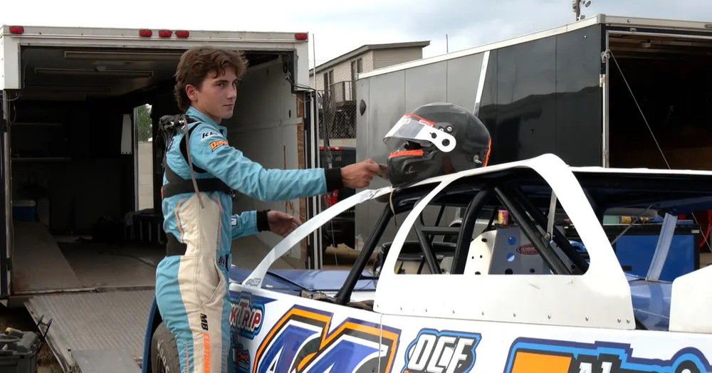 Cade Nelson places his helmet on his race car