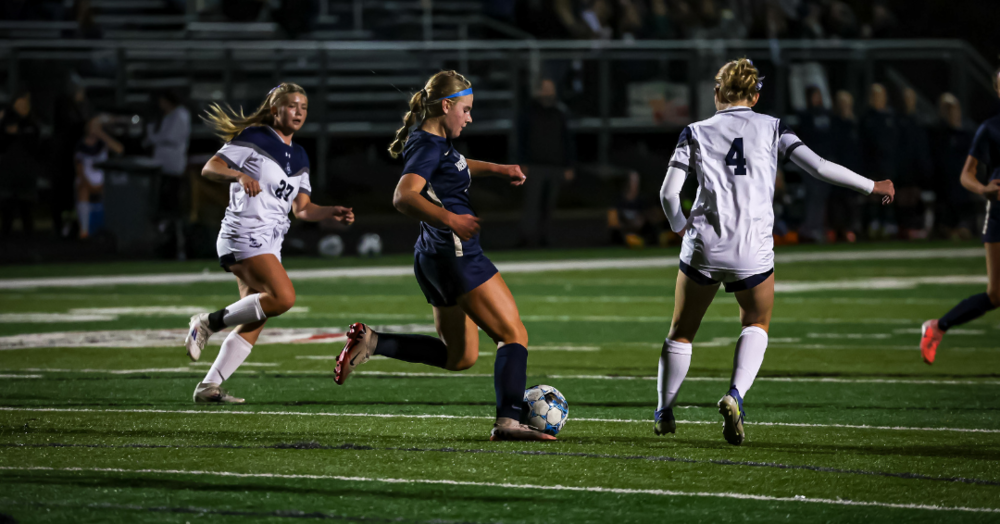 Hermantown girls soccer player dribbles ball