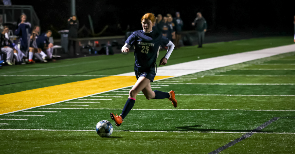 Hermantown girls soccer player on the field running after the ball