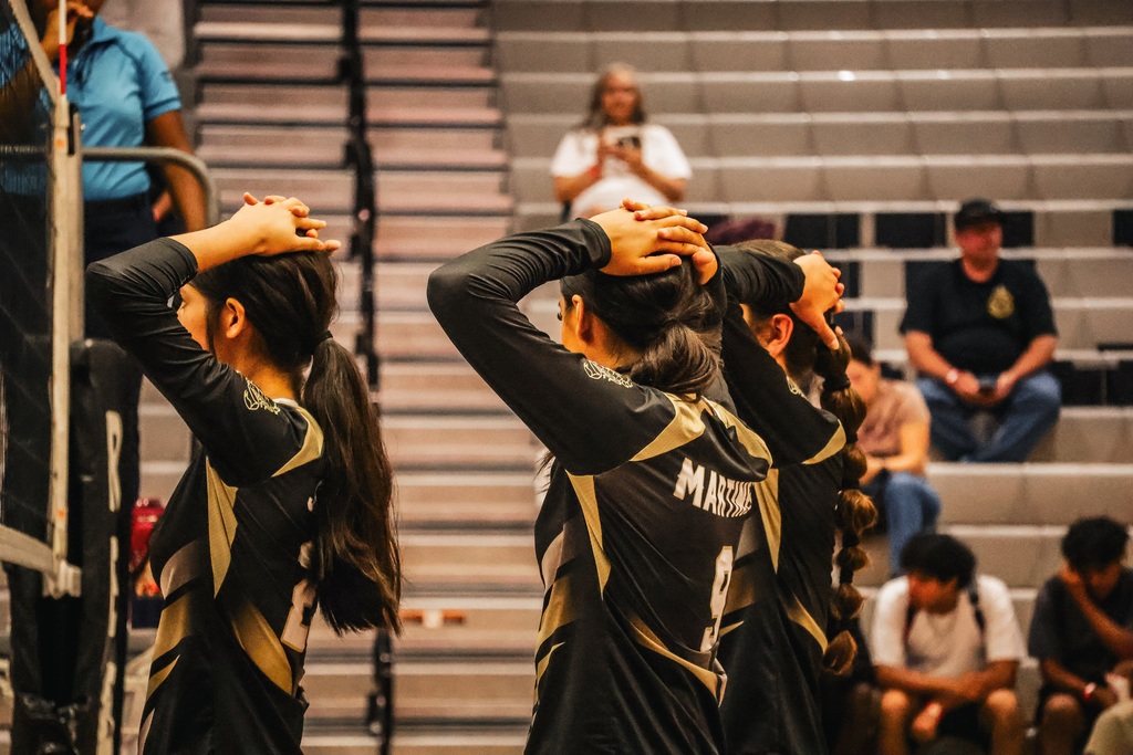 HHS players wait to defend the serve