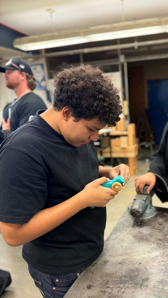 students in class working on wooden cars