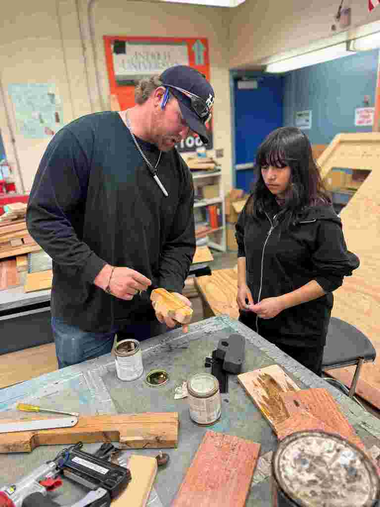 students in class working on wooden cars