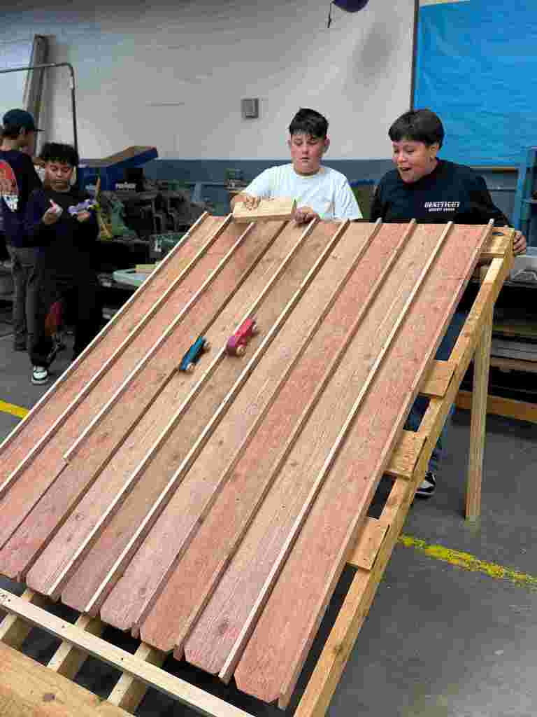 students in class working on wooden cars