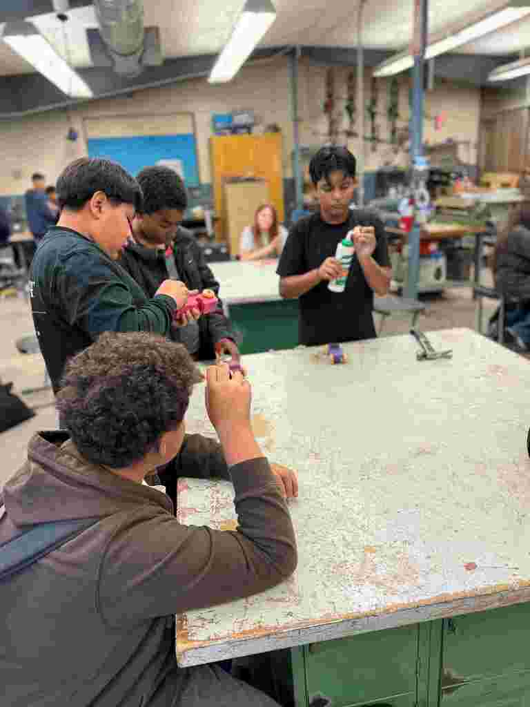 students in class working on wooden cars
