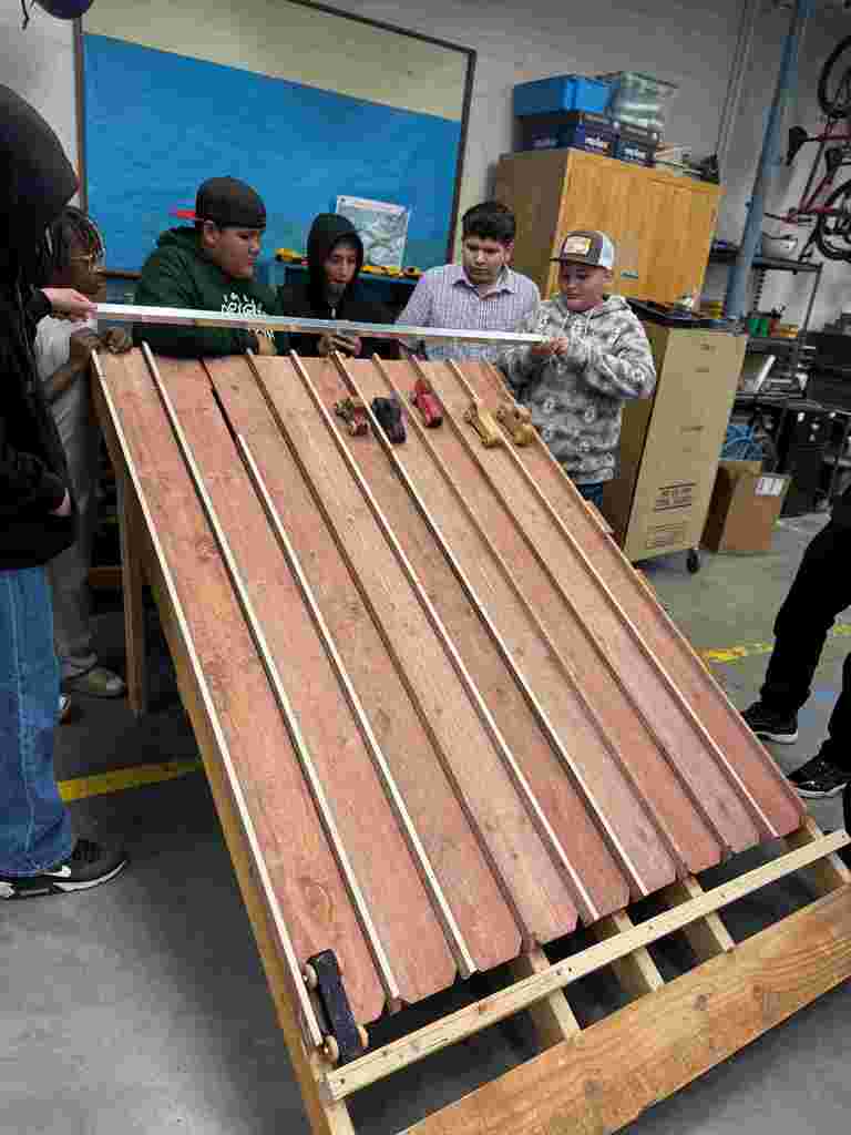 students in class working on wooden cars