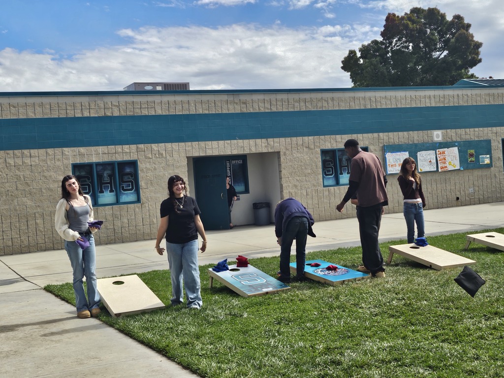 Students and staff competing in cornhole competition