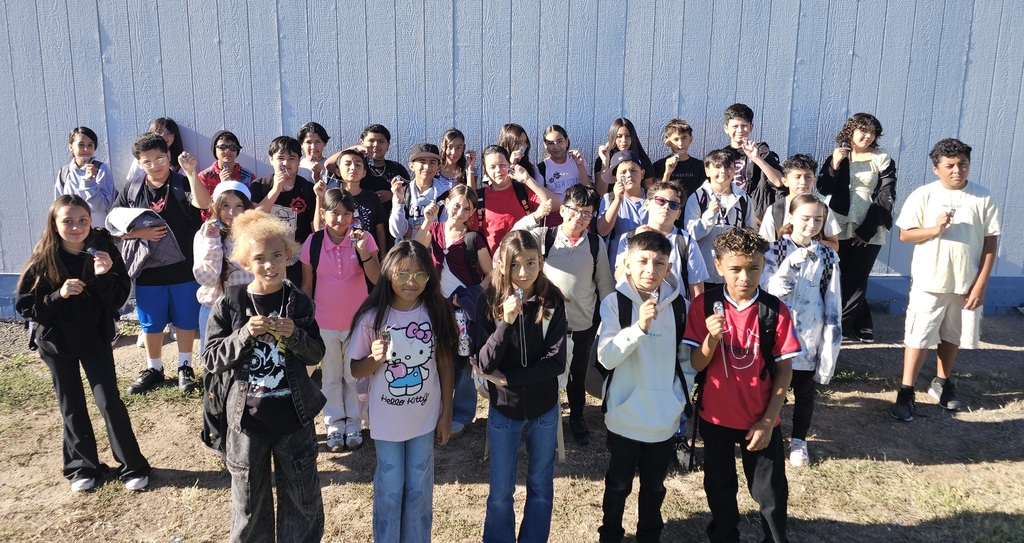 A collection of photos celebrating Joshua Circle Elementary students who earned Perfect Attendance Brag Tags. Students of various grade levels smile and proudly hold or wear their colorful brag tags on necklaces. The photos were taken around campus, including classrooms and outside the school. One large group photo shows several dozen students together, while the other photos feature smaller groups of students displaying their awards.