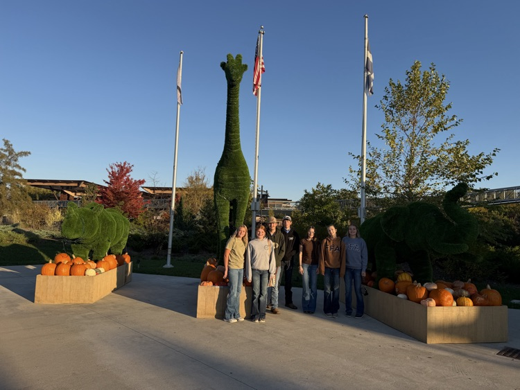 students in front of foliage 