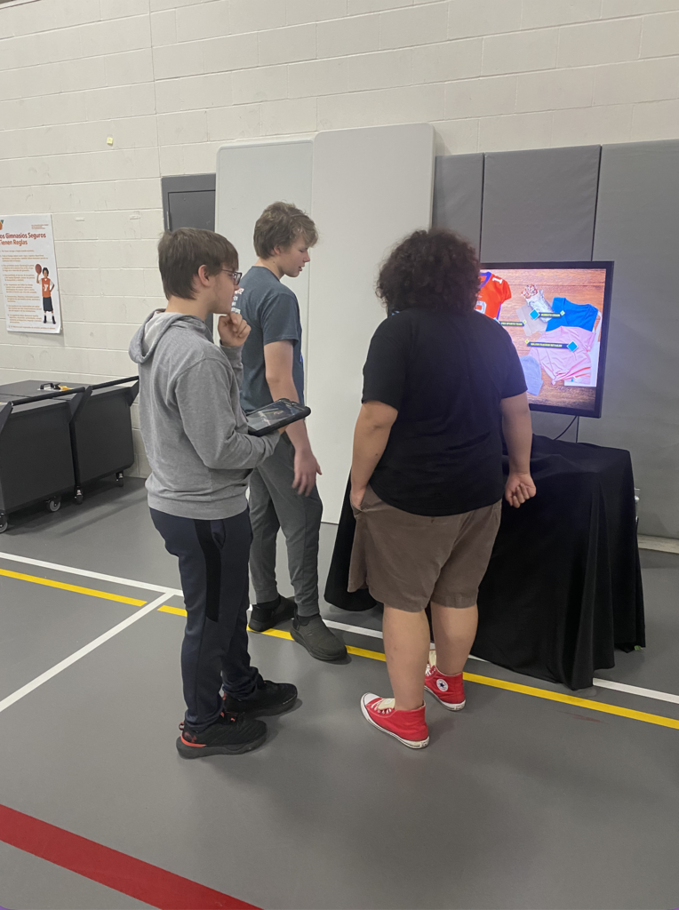 Three people gather around a flat-screen TV.