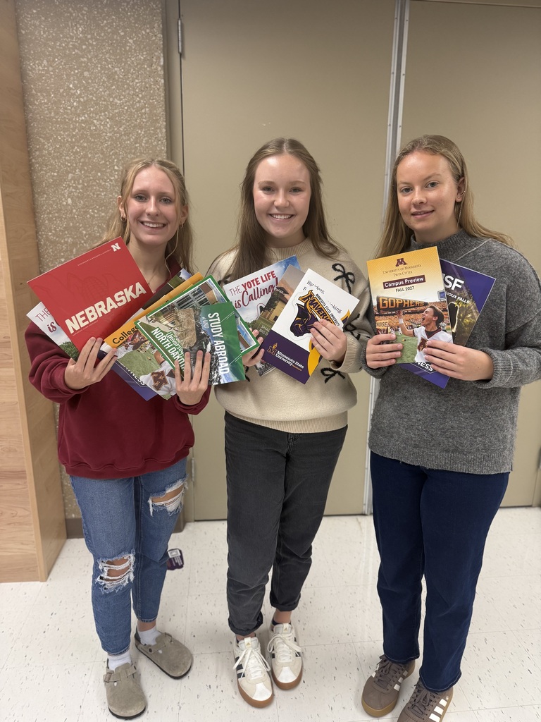 Three students holding college information they received at the college fair